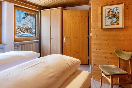 1 dormitorio con 2 camas, silla y ventana en Adlerhorst Amsel, en Santa Valpurga