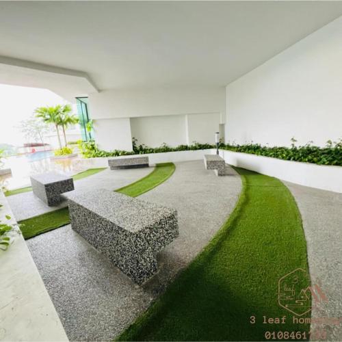 a courtyard with benches and grass in a building at KULAI IOI MALL D'Putra Suites Near JPO Senai Airport in Kampong Saleng