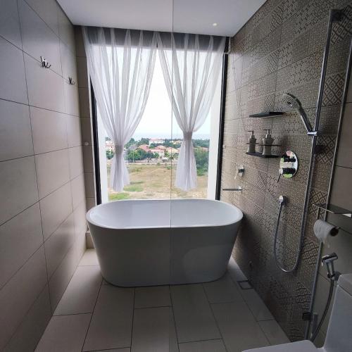 a bath tub in a bathroom with a window at Beach apartment apec Phú Yên in Tuy Hoa