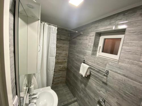 a bathroom with a toilet and a sink and a mirror at Apartman Downtown in Bosanski Novi