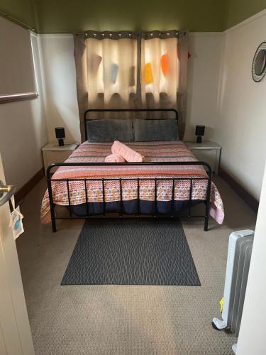 a bed in a small room with two night stands at Trippypossums House in Horsham