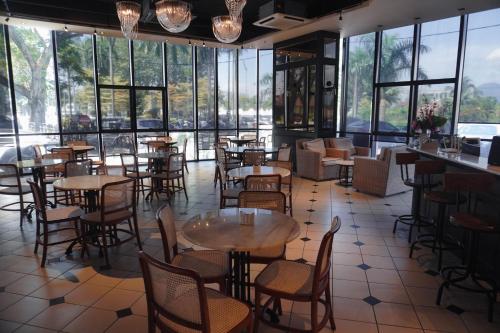 a restaurant with tables and chairs and large windows at M Roof Hotel & Residences in Ipoh
