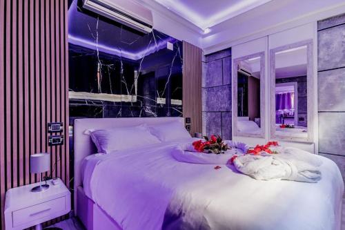 Un dormitorio púrpura con una cama grande con flores. en THESPASUITE Suite e Spa privata per coppie en Roma