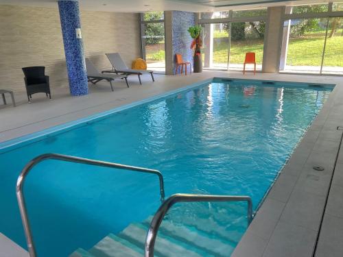 une grande piscine avec de l'eau bleue dans un immeuble dans l'établissement Domitys Les Portes de l'Atlantique, à Saint-Nazaire