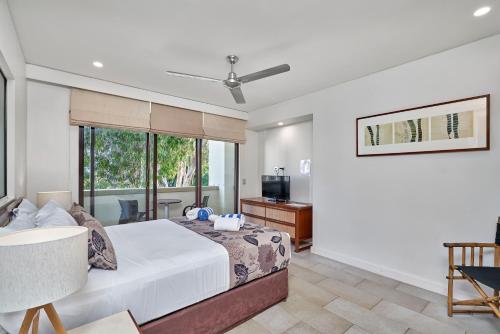 Un dormitorio con una cama grande y una ventana en Temple 312 Newly Refurbished Spacious Studio Resort Spa Apartment - UNDER NEW MANAGEMENT en Palm Cove