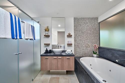 y baño con bañera y lavamanos. en Temple 312 Newly Refurbished Spacious Studio Resort Spa Apartment - UNDER NEW MANAGEMENT en Palm Cove