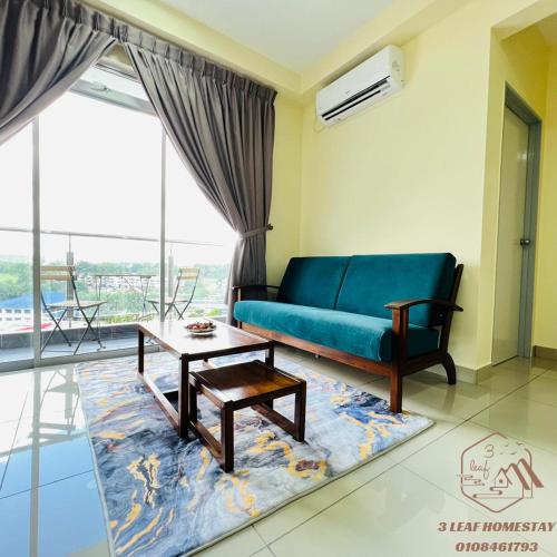 a living room with a blue couch and a table at KULAI IOI MALL D'Putra Suites Near JPO Senai Airport in Kampong Saleng