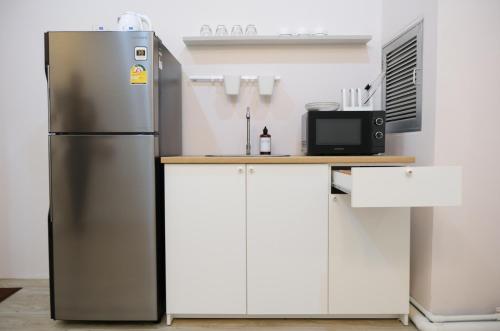 a stainless steel refrigerator in a kitchen with white cabinets at 2BR minimal mu-ji style 130SQM ~ in Makkasan