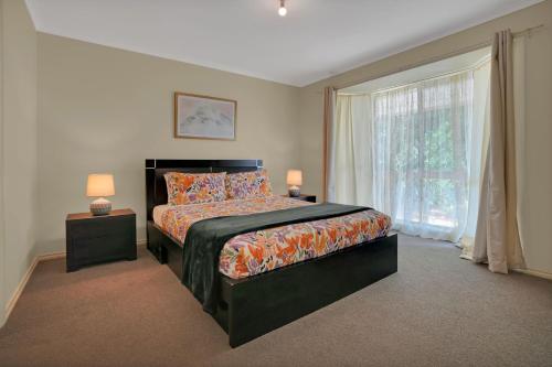 a bedroom with a bed and a large window at Serendipity in Port Fairy