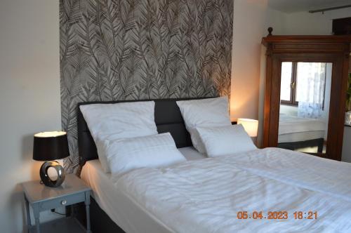 a bed with white pillows and a patterned wall at Dolomitenblick in Gerolstein