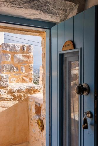 a door in a room with a stone wall at Lithos Stone Suites in Areopolis