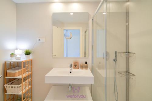 y baño blanco con lavabo y ducha. en weforyou Miradores del Sol 2 Bedrooms Apartment, en Estepona