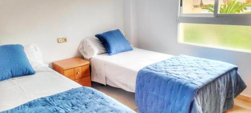 a small bedroom with two beds and a window at Apartamento en el Albir, Alfaz del Pi Playa in Albir