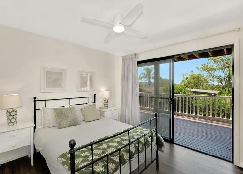 Un dormitorio con una cama y un balcón. en Hibiscus Hideaway, en Valla Beach