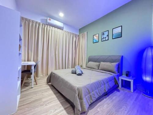 a blue bedroom with a bed and a desk at Jeff and Ricky Homestay 69 @P Residence in Kuching