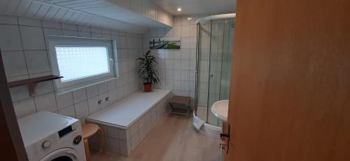 a bathroom with a tub and a sink and a window at Möwennest in Friederikensiel
