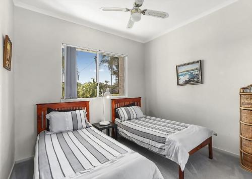 a bedroom with two beds and a window at Solitaire 1 in Sawtell