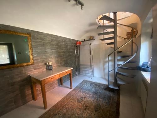 een kamer met een houten tafel en een wenteltrap bij Alloggio Sassi in Turijn