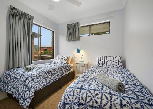 una camera da letto con due letti e una finestra di Ocean Sands 5 a Sawtell