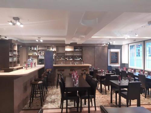 un restaurant avec des tables et des chaises et un bar dans l'établissement Studios étape du Lac, à Bourbon-Lancy