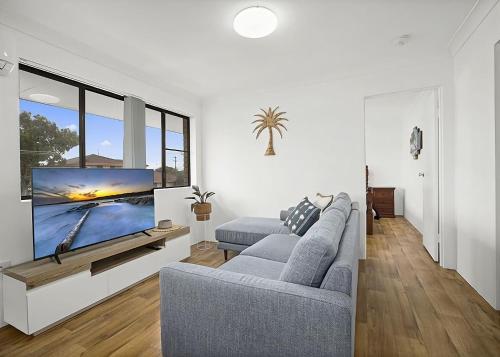 a living room with a couch and a flat screen tv at Blue Gem in Sawtell