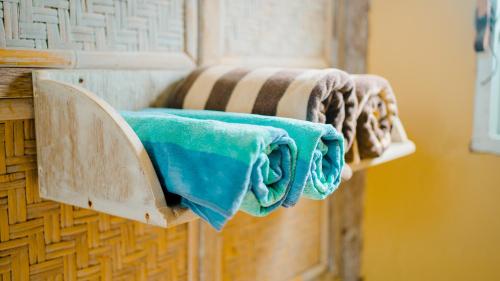 a couple of towels are hanging on a wall at Les Villas Ottalia Gili Meno in Gili Meno