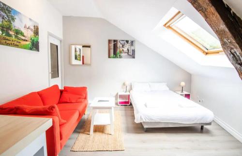 a living room with a red couch and a bed at Point calme & stratégique de Tours in Tours