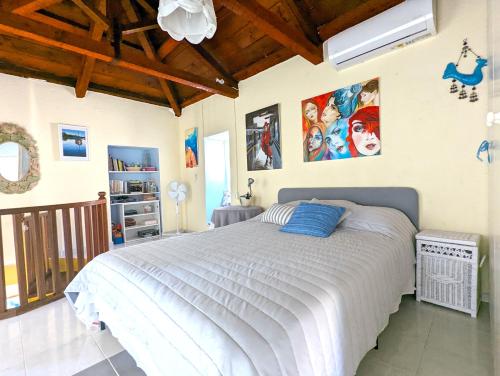 a bedroom with a large bed and some pictures on the wall at Ύδρα ivY in Hydra