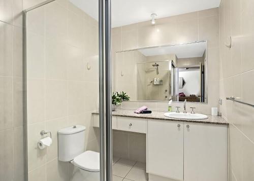 a white bathroom with a toilet and a sink at Ocean Pines in Nambucca Heads