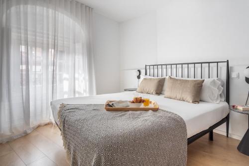 a bedroom with a bed with a tray of fruit on it at Aspasios Calle Mayor Apartments in Madrid