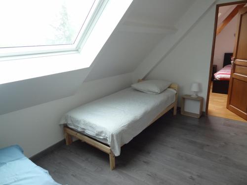 - un petit lit dans une chambre avec fenêtre dans l'établissement Gîte de l Alouette (3 Etoiles), à Grainville-Ymauville