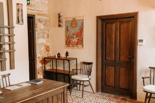 a room with a desk and chairs and a door at Nill's Stone House otel in Çeşme