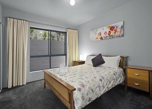 a bedroom with a bed and a large window at Waters Edge in Nambucca Heads