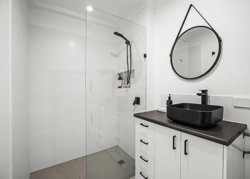 a bathroom with a sink and a mirror at Garden Spa Villa in Coffs Harbour