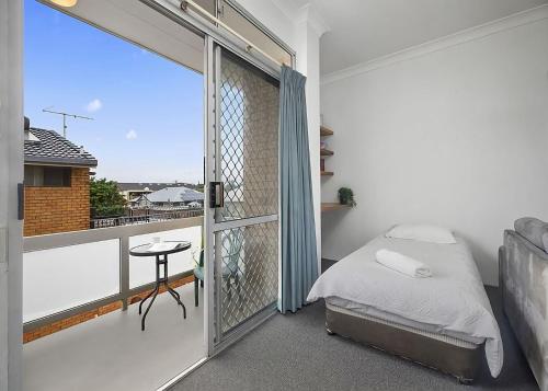 una camera con letto e un balcone con finestra di Coasters 9 a Sawtell