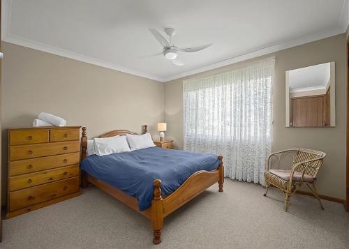 1 dormitorio con 1 cama, vestidor y ventana en Robys Retreat, en Sawtell