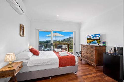 ein Schlafzimmer mit einem Bett, einer Kommode und einem Fenster in der Unterkunft Ciao Korora in Coffs Harbour