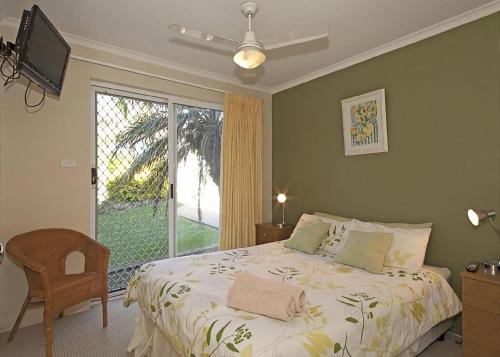 a bedroom with a bed and a large window at 1/17 22nd Ave - Sawtell, NSW in Sawtell