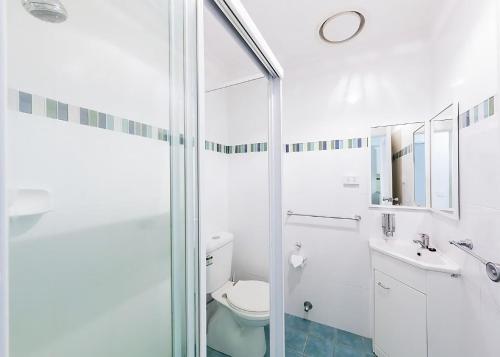 a bathroom with a toilet and a sink and a shower at Periwinkle in Sawtell