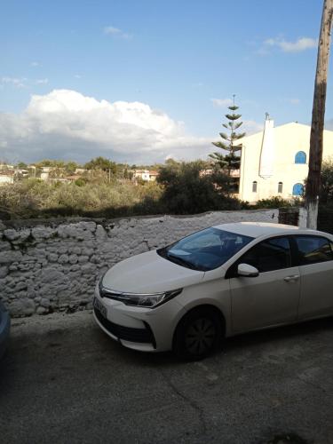 a white car parked next to a stone wall at Casa del Maestro in Prinés