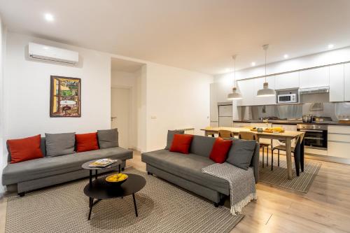 a living room with a couch and a table and a kitchen at Aspasios Calle Mayor Apartments in Madrid