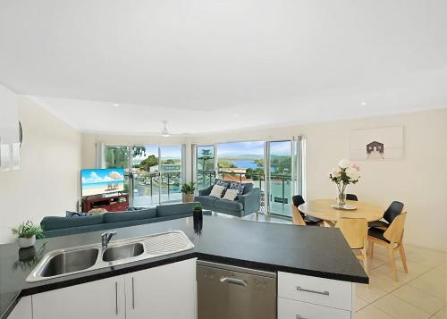 a kitchen and a living room with a table at Beauty on Bowra in Nambucca Heads