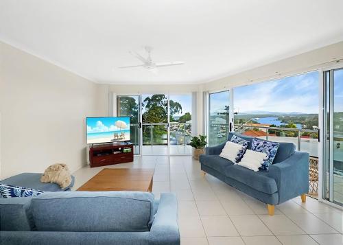 a living room with two couches and a tv at Beauty on Bowra in Nambucca Heads