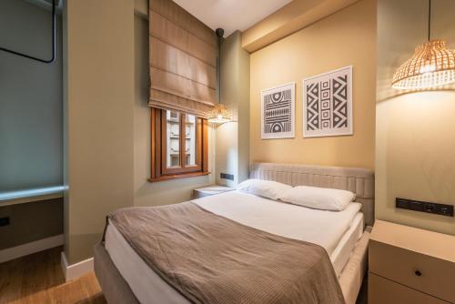 een slaapkamer met een bed en een raam bij Bguest Pera Suites in Istanbul