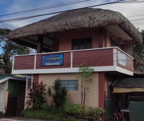 a building with a balcony on the side of it at Alexandra's Transient Haus in Donsol