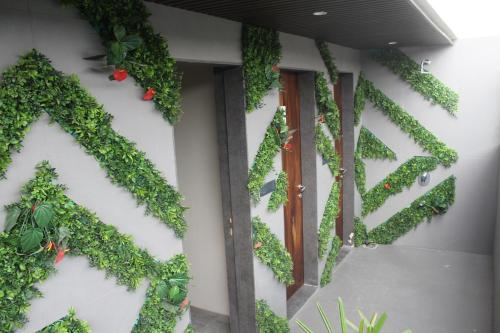 a building with green ivy on the wall at Hotel Rudra Royals in Shirdi