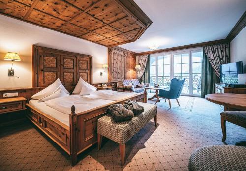 sypialnia z dużym łóżkiem i salonem w obiekcie Hotel Post Lermoos w mieście Lermoos