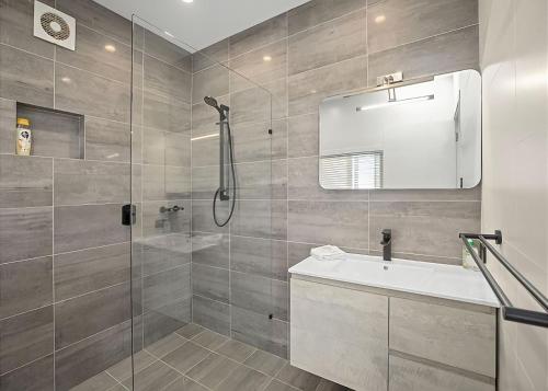 uma casa de banho com um chuveiro e um lavatório. em Gurruja Retreat em Scotts Head