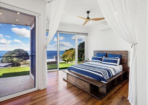 um quarto com uma cama e uma grande janela em Gurruja Retreat em Scotts Head