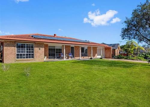 a brick house with a lawn in front of it at Geoff and Mary s in Urunga